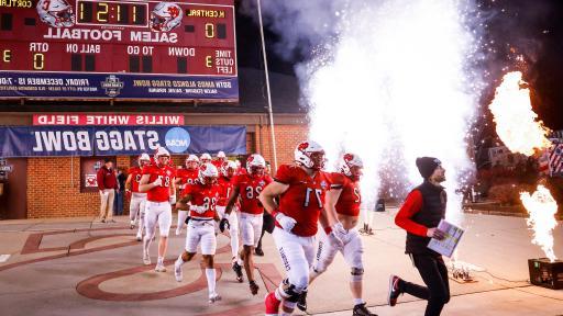 The North Central football team runs onto the field at the Stagg Bowl.